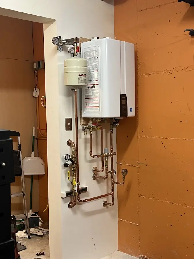 Plumbing technician inspecting water heater connections in Griffin